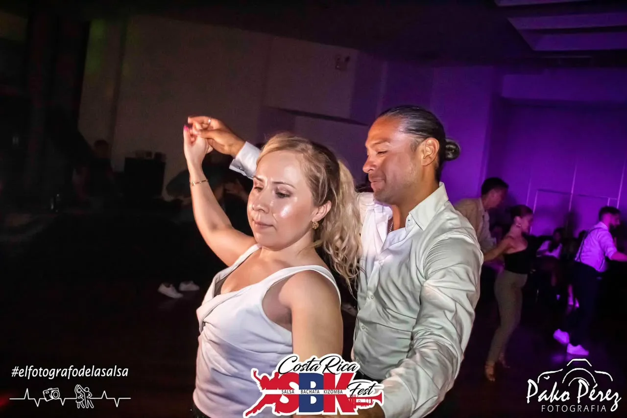 Pareja bailando bajo luces moradas
